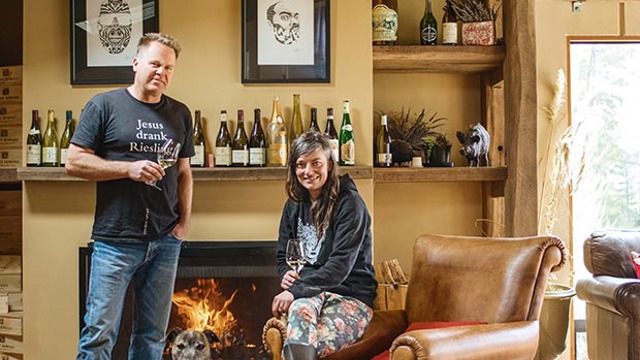 Duncan Forsyth and Anna Riederer infront of a fireplace with a dog