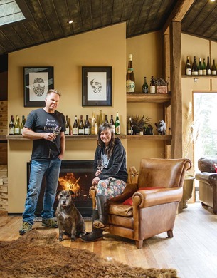 Duncan Forsyth and Anna Riederer infront of a fireplace with a dog
