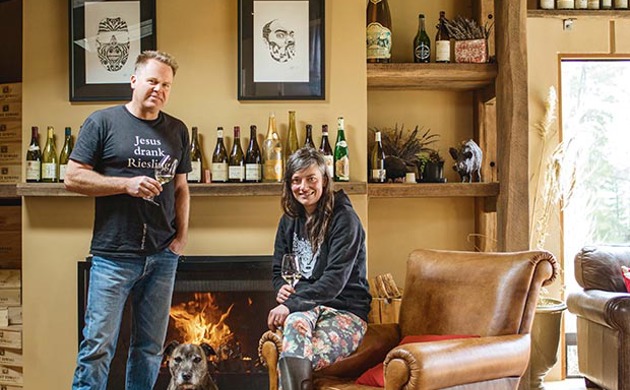 Duncan Forsyth and Anna Riederer infront of a fireplace with a dog