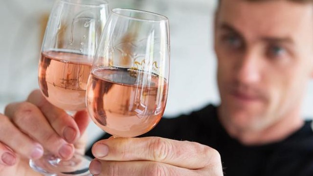 A man holding two glasses of a pink wine from Untitled Wines