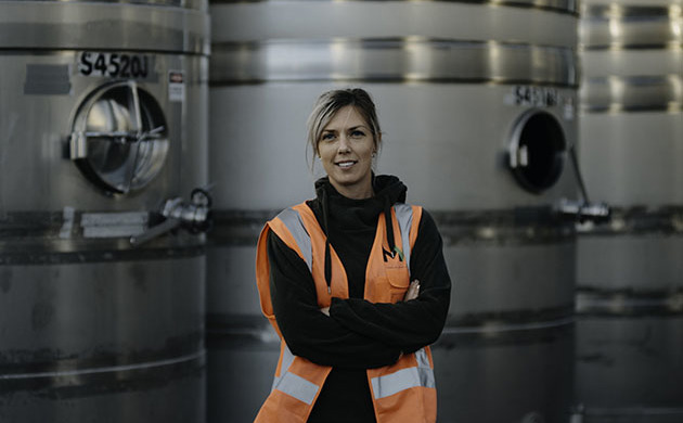 Alice Rule standing infront of tanks in a winery