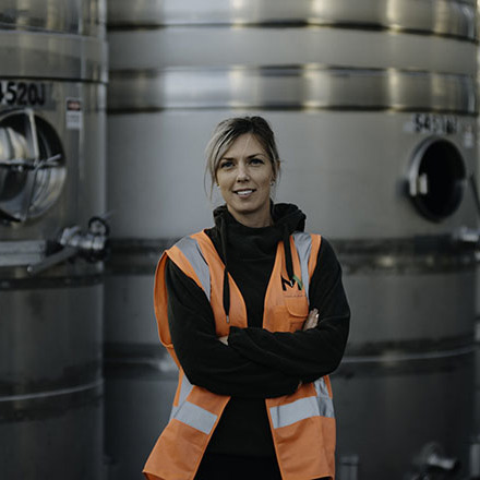 Alice Rule standing infront of tanks in a winery