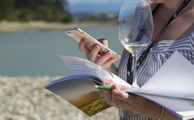 Woman holding wine glass and using mobile