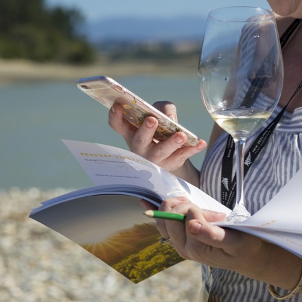 Woman holding wine glass and using mobile